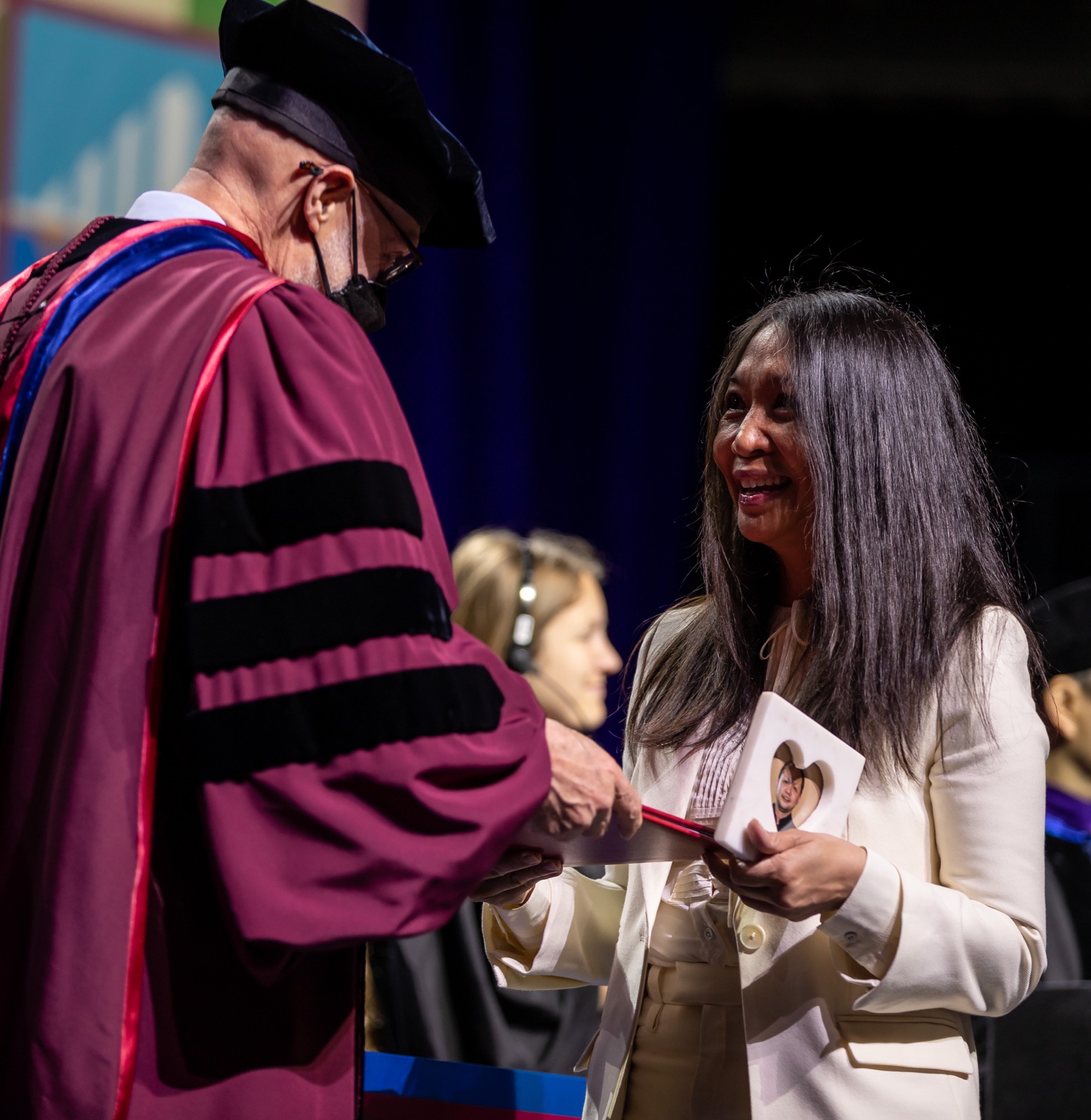 Jeanette Fernandez-Rockey accepts a posthumous degree for her brother, Joel Quiachon Fernandez, a student in the Jarvis College of Computing and Digital Media.